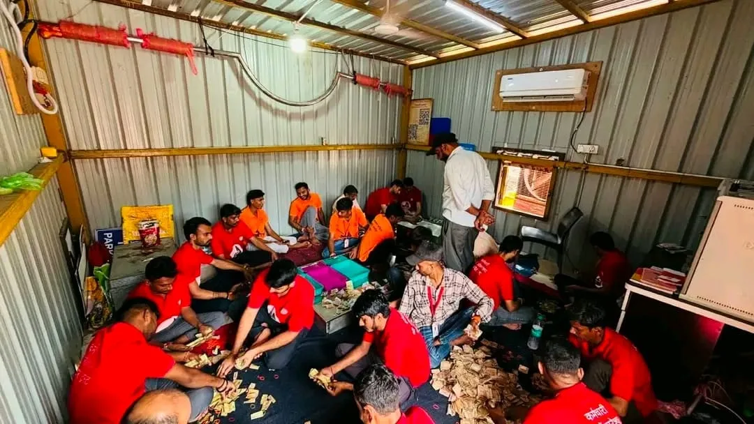 ओंकारेश्वर मंदिर के दानपात्रों से प्राप्त राशि की गणना करते मंदिर कर्मचारी और बैंक कर्मचारी